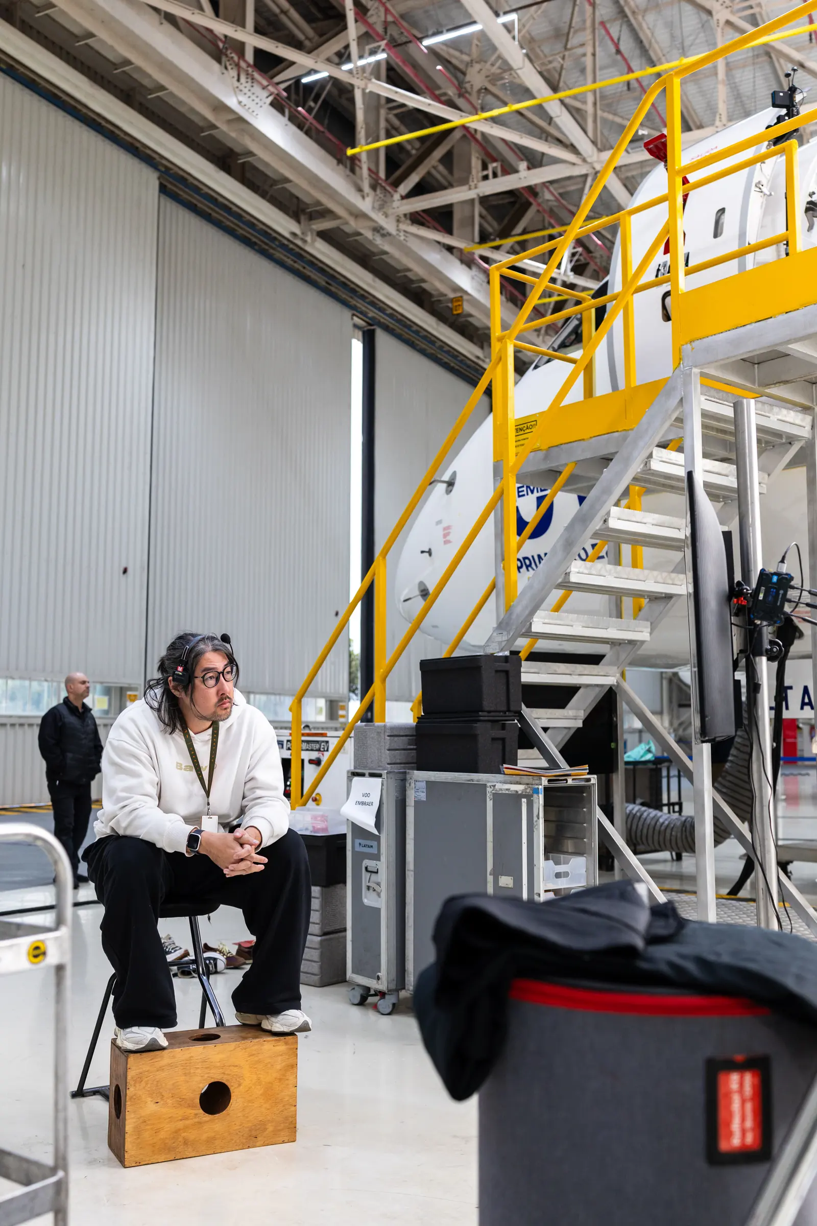 An interviewee seated on an apple box beside the boarding stairs