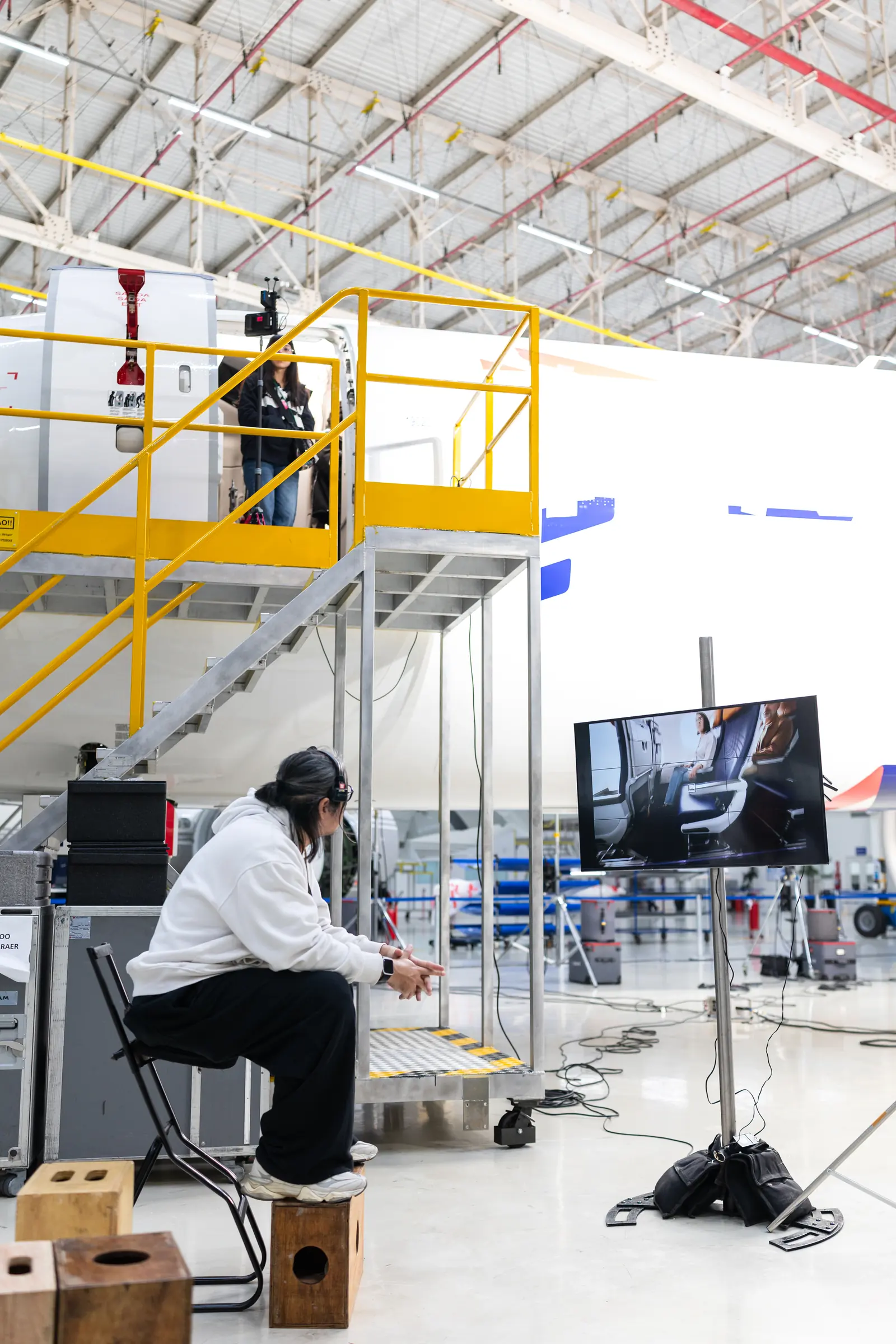 The interviewee between takes, next to the monitor showing the frame